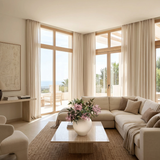 NO. 74 by Nicolíe de Luxe: pink holly fruit berries and deep green foliage in a round cream stoneware vase, styled on a travertine coffee table in a Marbella villa lounge