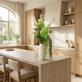 NO. 21 by Nicolíe de Luxe: green hydrangeas, cream delphinium and trailing green amaranthus in a slim cream vase, styled on a travertine kitchen island in a bright villa kitchen